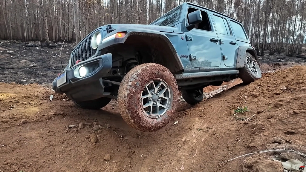 Veículo off-road atravessando trecho com água e pedras